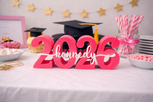 Graduation-themed table setup with '2026' and 'kennedy' decorations. Graduation-themed table setup with '2026' and 'kennedy' decorations.