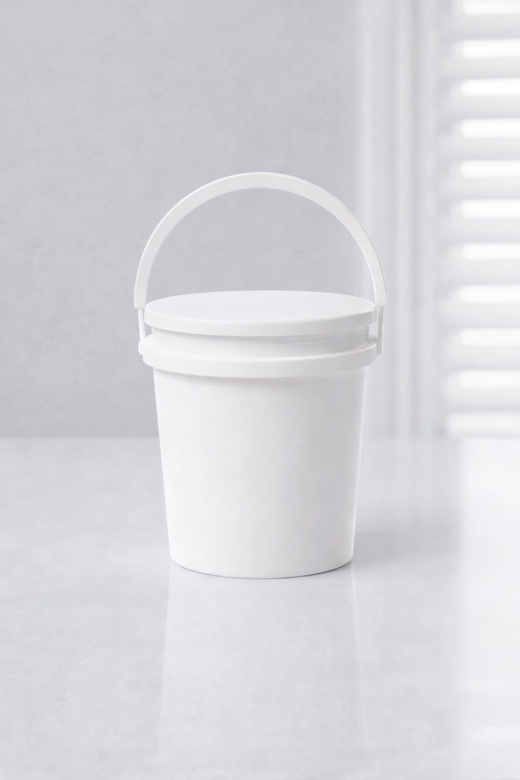 White bucket with a handle on a light gray background