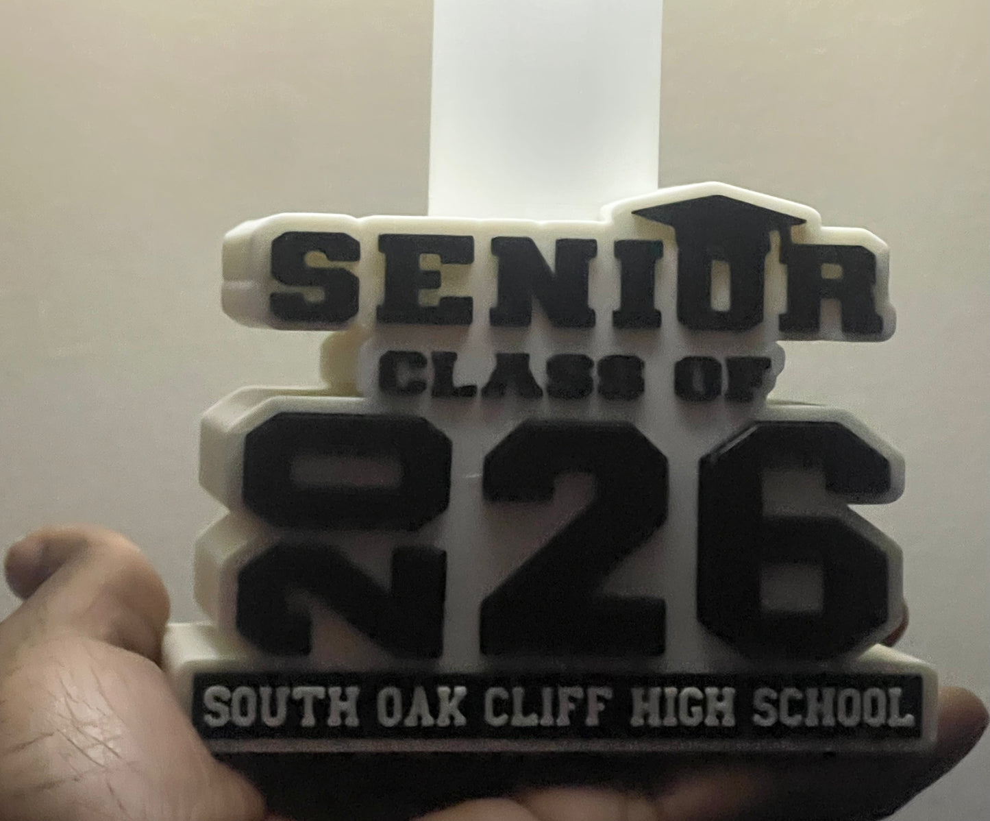 3D-printed plaque with 'Senior Class of 2026' text held by a hand against a white background