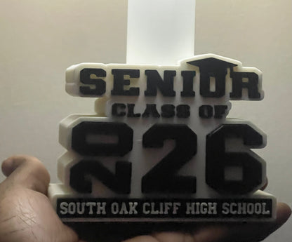3D-printed plaque with 'Senior Class of 2026' text held by a hand against a white background