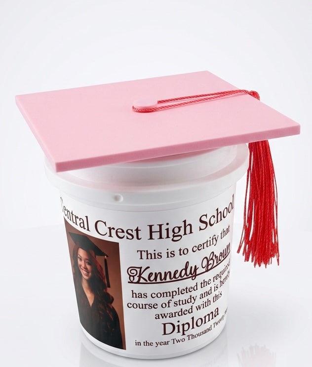 Graduation-themed container with pink cap and pink tassel on a white background