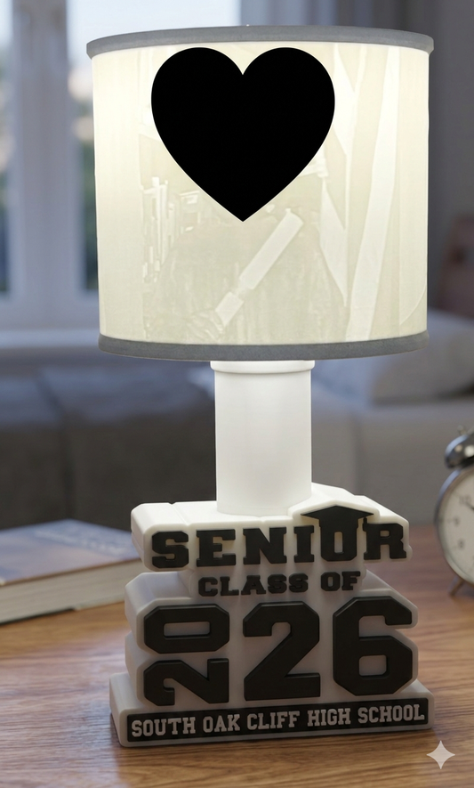 Lamp with heart design and 'Senior Class of 2026' text on a wooden surface.