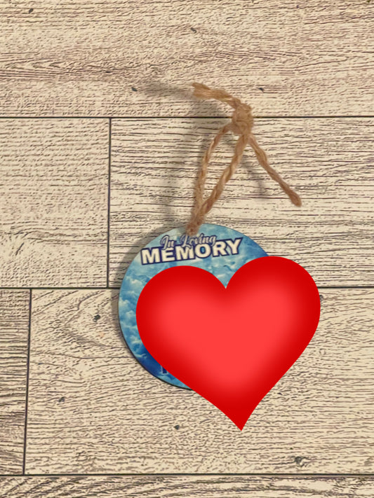 Round ornament with 'In Loving Memory' text and picture on a wooden surface